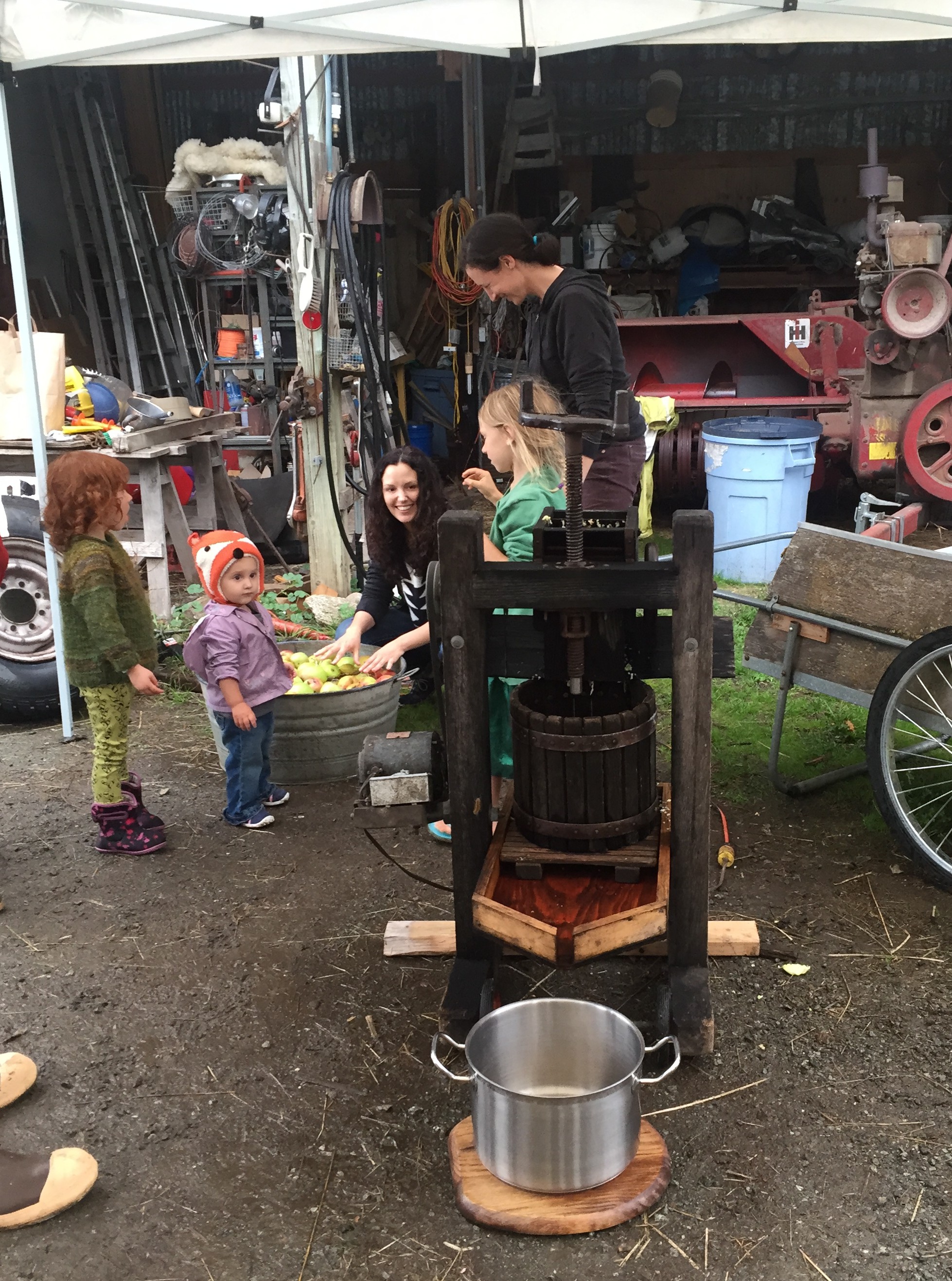 Family and friends learning about old fashion cider making